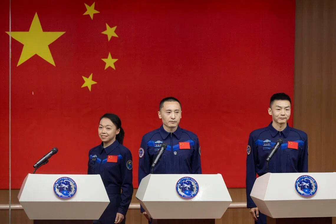 Astronauts of the Shenzhou-23 space mission (from left) Li Jiaying or Lai Ka-ying, Zhu Yangzhu and Zhang Zhiyuan, arriving at the press conference for the presentation of their mission on May 23, 2026. 