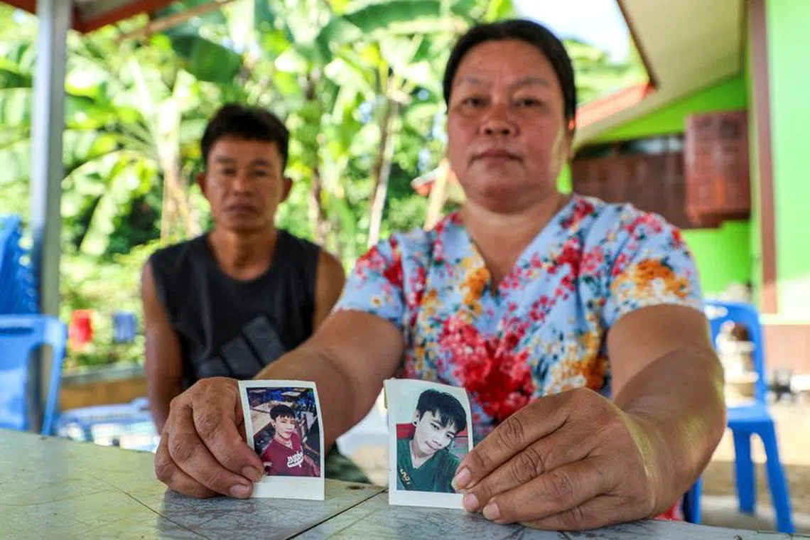 Thawatchai and Thongkoon On-kaew, parents of Natthaporn, who was working in Israel and has been abducted in the ongoing conflict between Israel and the Palestinian Islamist group Hamas, hold up his pictures during an interview with Reuters at their house in Nakhon Phanom, Thailand, October 10, 2023. REUTERS/Thomas Suen REFILE - CORRECTING "A FACTORY WORKER IN GAZA" TO "WHO WAS WORKING IN ISRAEL\