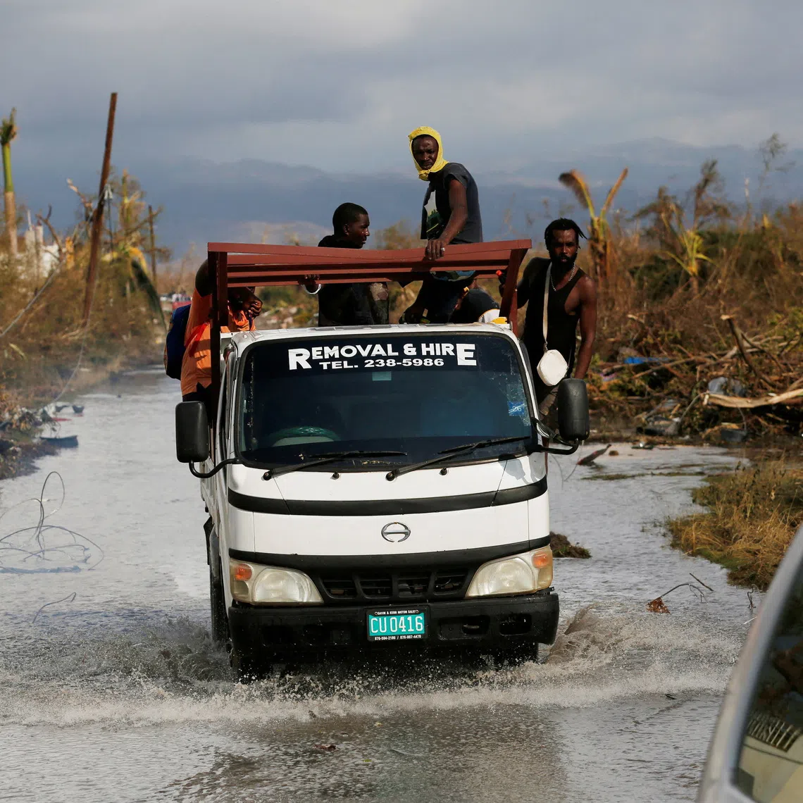 Vehicles drive through a flooded road after Hurricane Melissa made landfall, in Black River, Jamaica, October 30, 2025. REUTERS/Octavio Jones