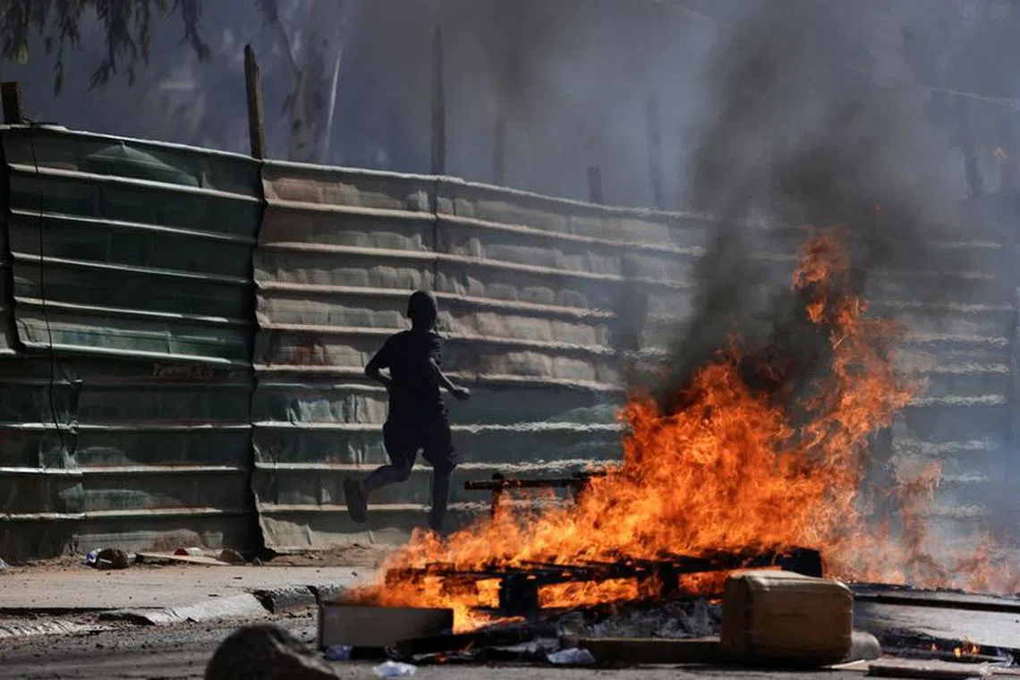 A boy runs past barricades as Senegalese demonstrators clash with riot police during a protest against the postponement of the Feb. 25 presidential election, in Dakar, Senegal February 4, 2024. REUTERS/Zohra Bensemra