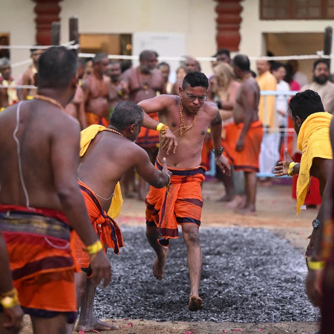 Devotees crossing the fire pit at Sri Mariamman Temple during the annual theemithi vizha, or fire walking festival, on Oct 12, 2025. 