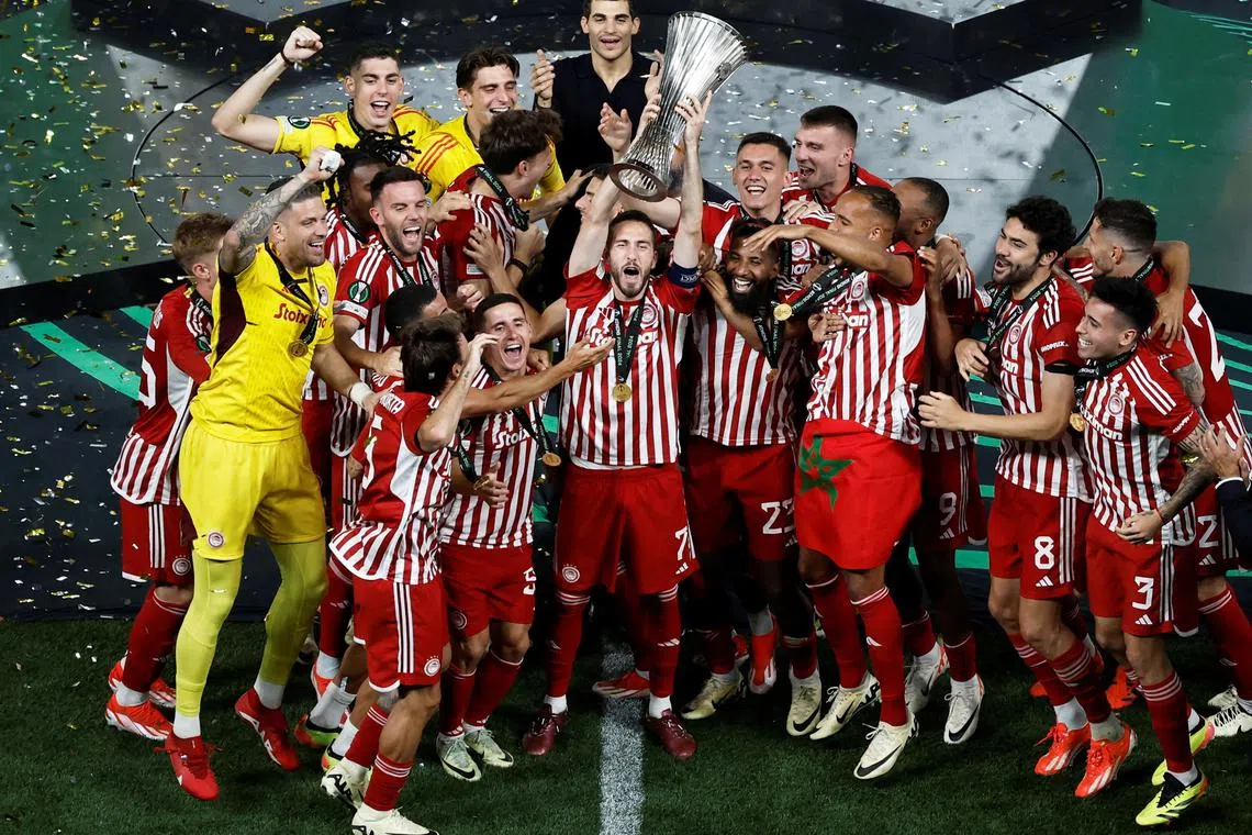 Soccer Football - Europa Conference League - Final - Olympiacos v Fiorentina - Agia Sophia Stadium, Athens, Greece - May 30, 2024 Olympiacos' Kostas Fortounis lifts the trophy as he celebrates with teammates after winning the Europa Conference League REUTERS/Louisa Gouliamaki
