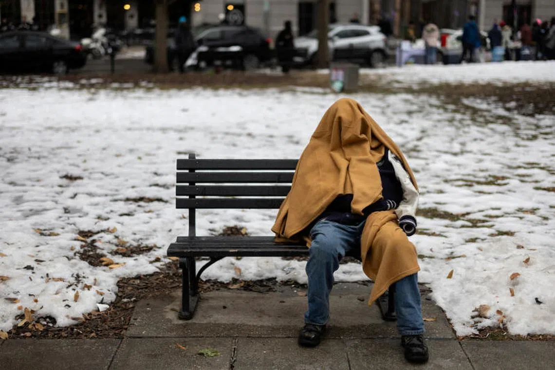 A homeless person sits on a bench in a park in Washington, ranked 15th among major US cities by homeless population.