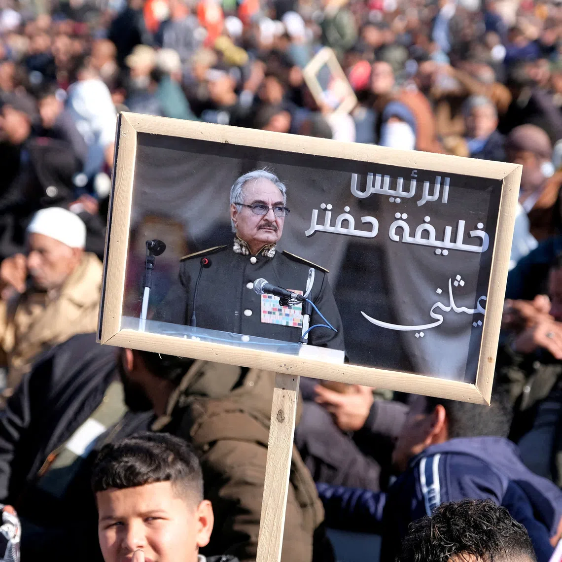 FILE PHOTO: A man holds a picture of commander Khalifa Haftar during Independence Day celebrations in Benghazi, Libya December 24, 2022. REUTERS/Stringer/File Photo