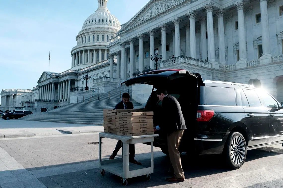 Congressional staff unload boxes of pizza outside the Capitol during a “vote-a-rama” on Capitol Hill in Washington on June 4.
