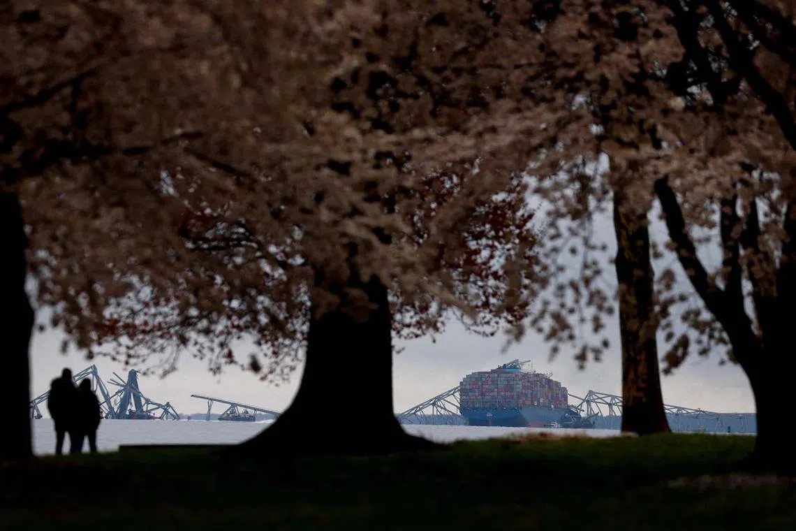 People looking at the collapsed Francis Scott Key Bridge while visiting Fort McHenry in Baltimore, Maryland, US, March 27, 2024. 