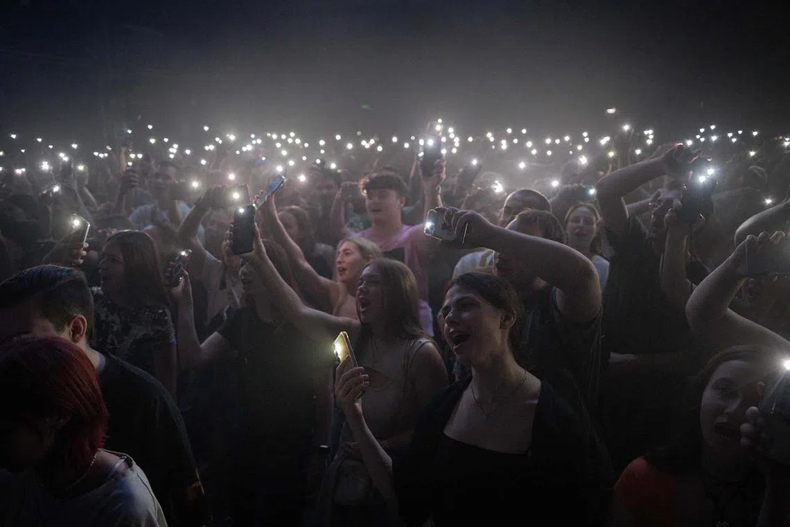 People attending the performance of Ukrainian music band Kurgan And Aggregate in the basement of a theatre at their charity concert in support of the Armed Forces of Ukraine in Kharkiv on June 11, 2025, amid the Russian invasion in Ukraine. 
