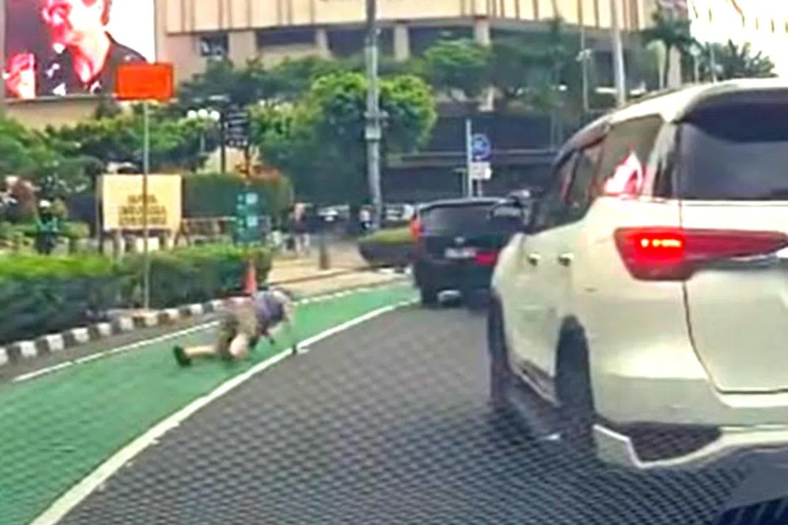 A tourist falls onto the road after attempting to chase a motorcyclist who allegedly snatched his phone near Jakarta’s Hotel Indonesia (HI) traffic circle on May 14.