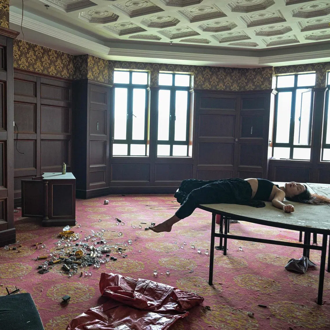 This photo taken on May 24 shows Xu Pengcheng (left) taking pictures of model Mao Yi as she poses on a table at a room inside an abandoned hotel in Shanghai. 