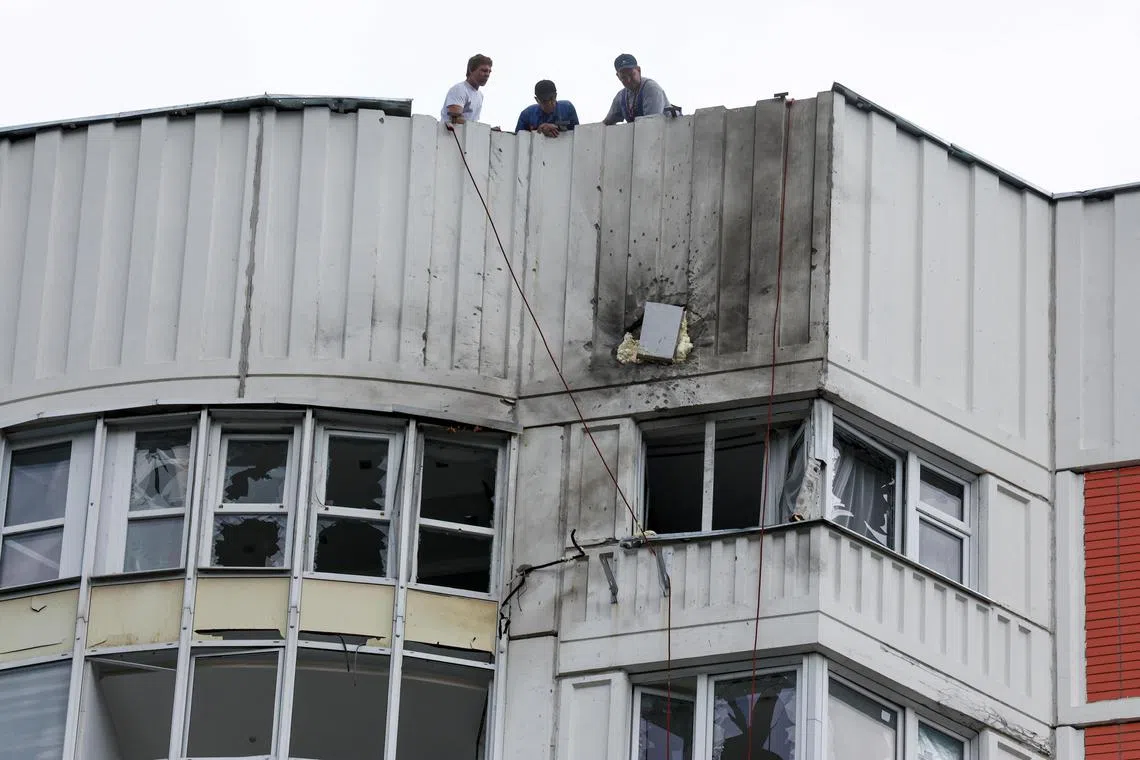 Men are seen on the roof of a damaged multi-storey apartment block following a reported drone attack in Moscow, on May 30. 