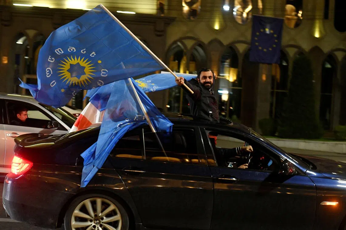 A supporter of the Georgian Dream party waves the party's flags from a car after the announcement of exit poll results in parliamentary elections, in Tbilisi, Georgia October 26, 2024. REUTERS/Zurab Javakhadze/File 
Photo