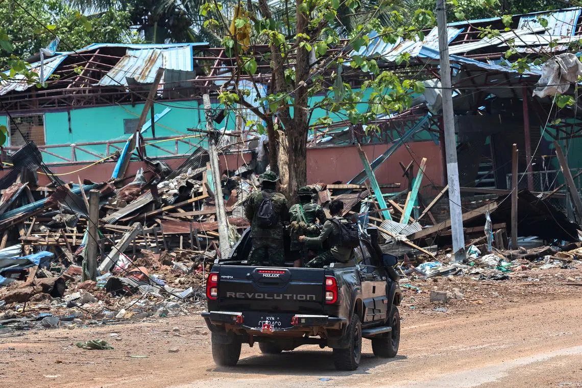 FILE PHOTO: Soldiers from the Karen National Liberation Army (KNLA) patrol on a vehicle, next to an area destroyed by Myanmar's airstrike in Myawaddy, the Thailand-Myanmar border town under the control of a coalition of rebel forces led by the Karen National Union, in Myanmar, April 15, 2024. REUTERS/Athit Perawongmetha/File Photo