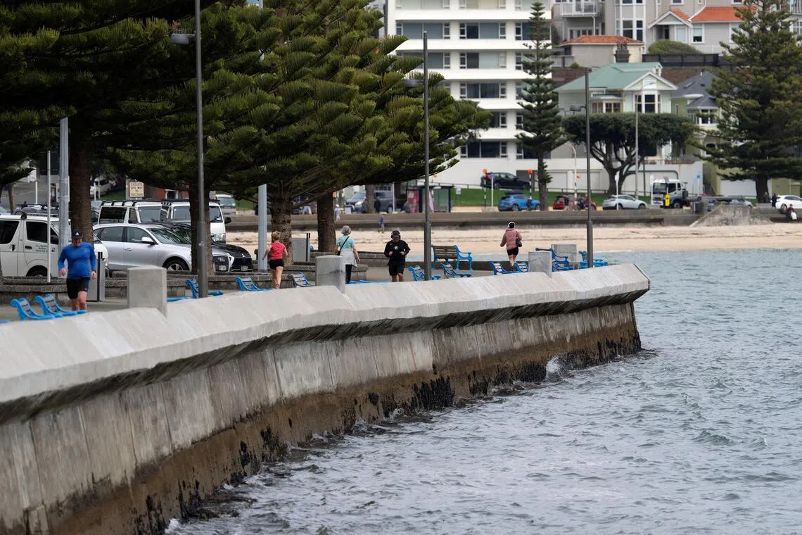 People walk and jog on Oriental Parade in Wellington, New Zealand, September 24, 2025. REUTERS/Marty Melville