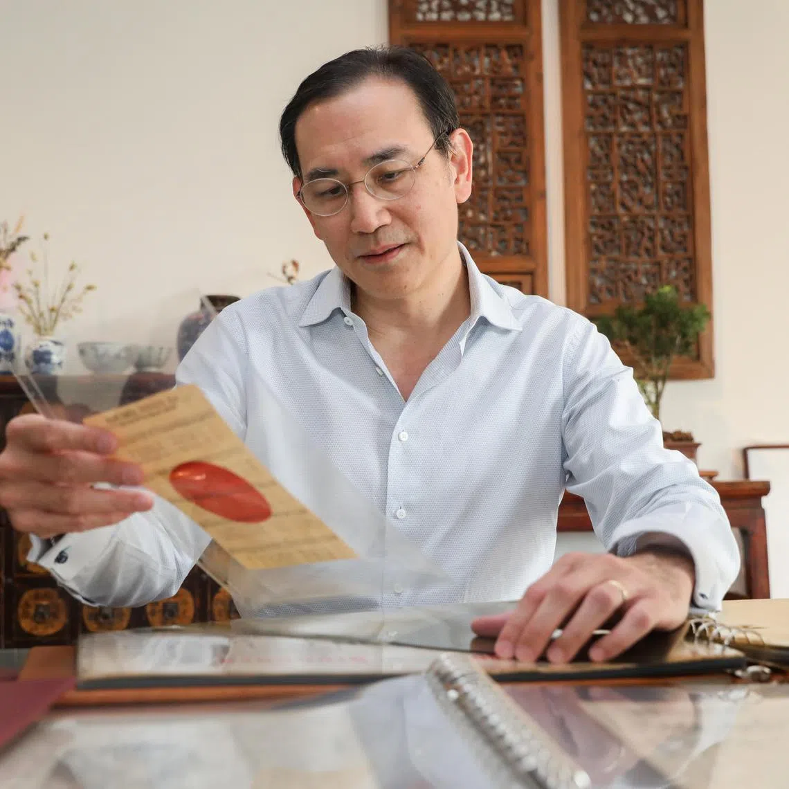 Dr Benjamin Seet looking through his 30 years collection of propaganda leaflets used in Singapore, Malaya & SEA (during WW2 & Malayan Emergency).