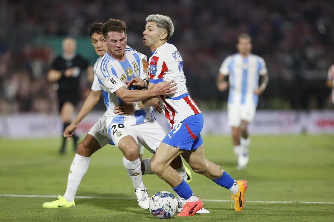 Julio Enciso of Paraguay vies for the ball with Alexis Mac Allister of Argentina during their World Cup qualifier.