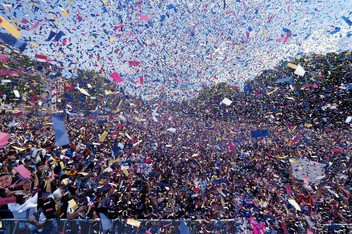 Confetti flies as Denver Nuggets fans celebrate during the championship parade after the Denver Nuggets won the 2023 NBA Finals. 