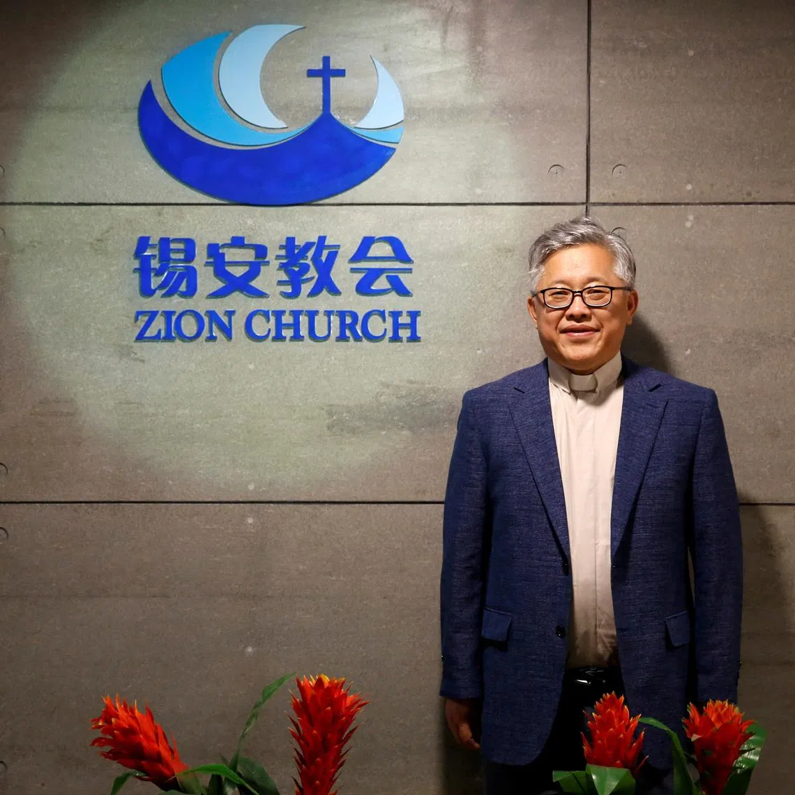 FILE PHOTO: The head pastor of the Zion church in Beijing Jin Mingri poses for picures in the lobby of the unofficial Protestant \"house\" church in Beijing, China, August 28, 2018.  Picture taken August 28, 2018.  REUTERS/Thomas Peter/File Photo