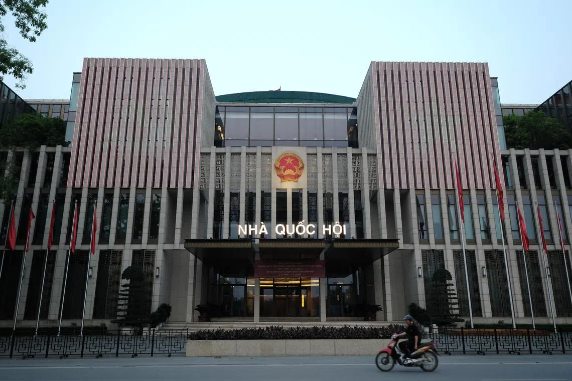 A man rides motorbike past the National Assembly building in Hanoi, Vietnam, on April 26, 2024.