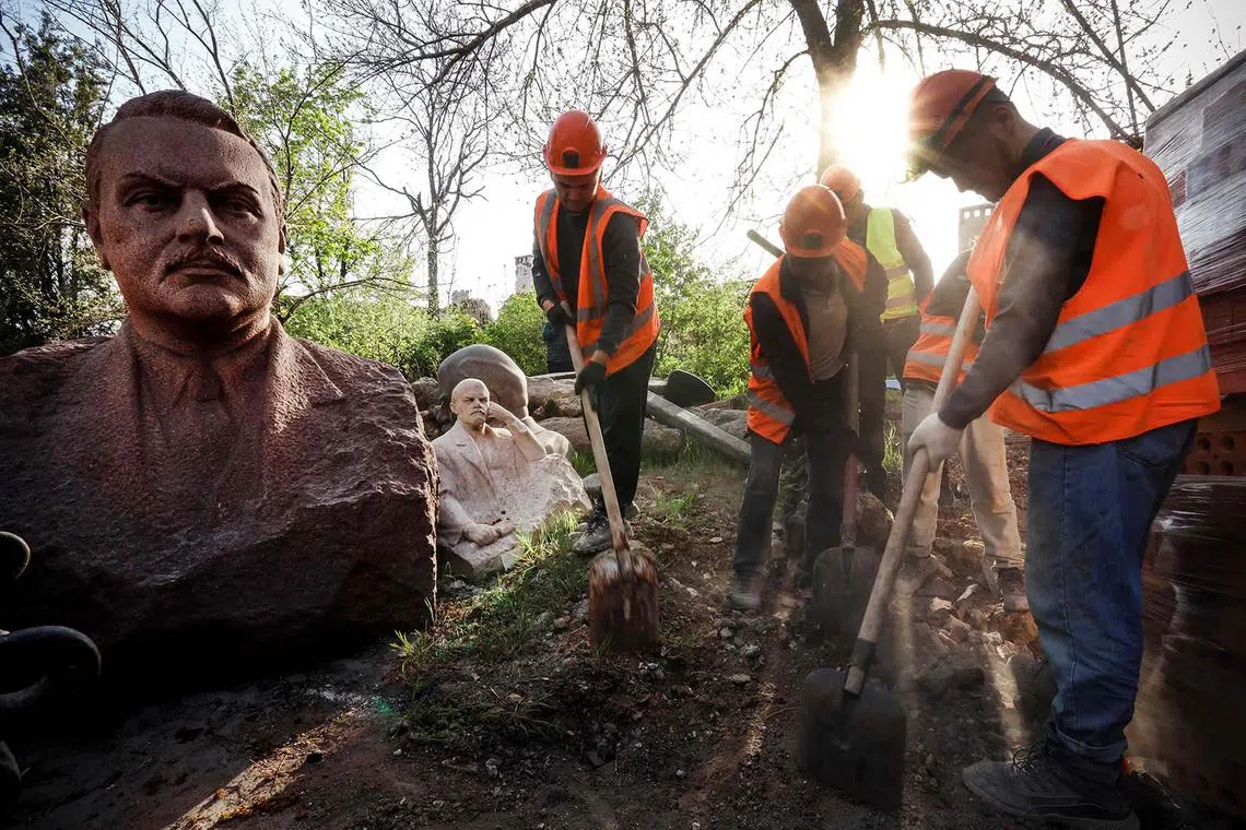 Workers cleaning debris around sculptures of historical figures at the destroyed local History museum in Mariupol, in Russian-controlled Ukraine, on April 15, 2024, amid the Russia-Ukraine conflict. 