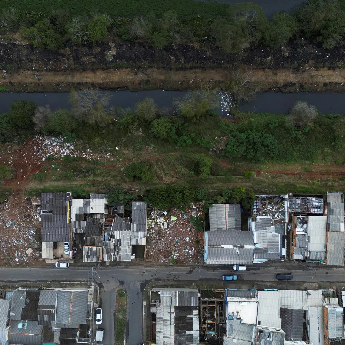 A drone view of homes and empty plots along the banks of the Sarandi Stream, where houses were demolished for the Sarandi levee expansion project following the devastating 2024 floods, in Porto Alegre, Brazil, June 8, 2026. REUTERS/Diego Vara