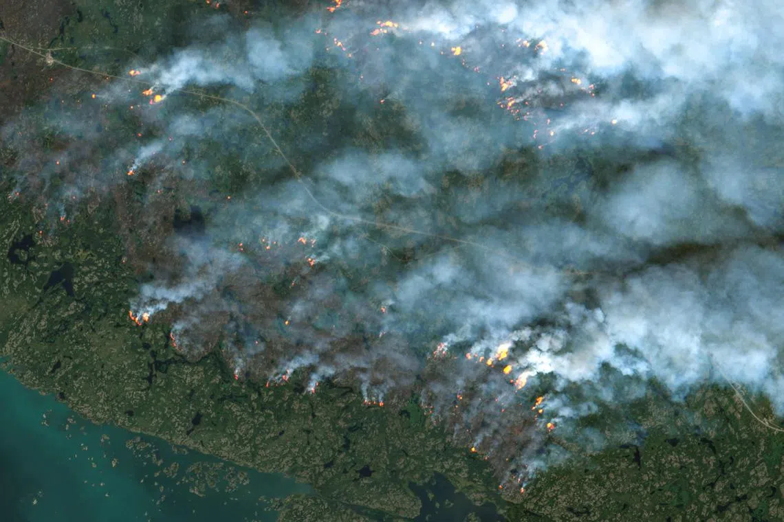 TOPSHOT - This handout satellite image courtesy of the European Space Agency's (ESA) Copernicus Sentinel-2 sattelite taken on August 16, 2023 shows fires burning in Yellowknife, Northwest Territories, Canada. Thousands ordered to flee wildfires advancing on one of the largest cities in Canada's far north started leaving on emergency evacuation flights August 17, 2023, as convoys snaked south to safety on the only open highway. The order late August 16 to evacuate Yellowknife in the Northwest Territories marked the latest chapter of a terrible summer for wildfires in Canada, with tens of thousands of people forced to leave their homes and vast swaths of land scorched. (Photo by EUROPEAN SPACE AGENCY / AFP) / RESTRICTED TO EDITORIAL USE - MANDATORY CREDIT "AFP PHOTO / European Space Agency (ESA)" - NO MARKETING NO ADVERTISING CAMPAIGNS - DISTRIBUTED AS A SERVICE TO CLIENTS