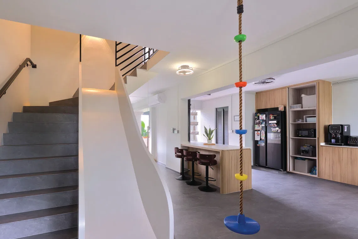 Colourful playground elements inject a cheerful touch into a family's neutral-toned executive maisonette.