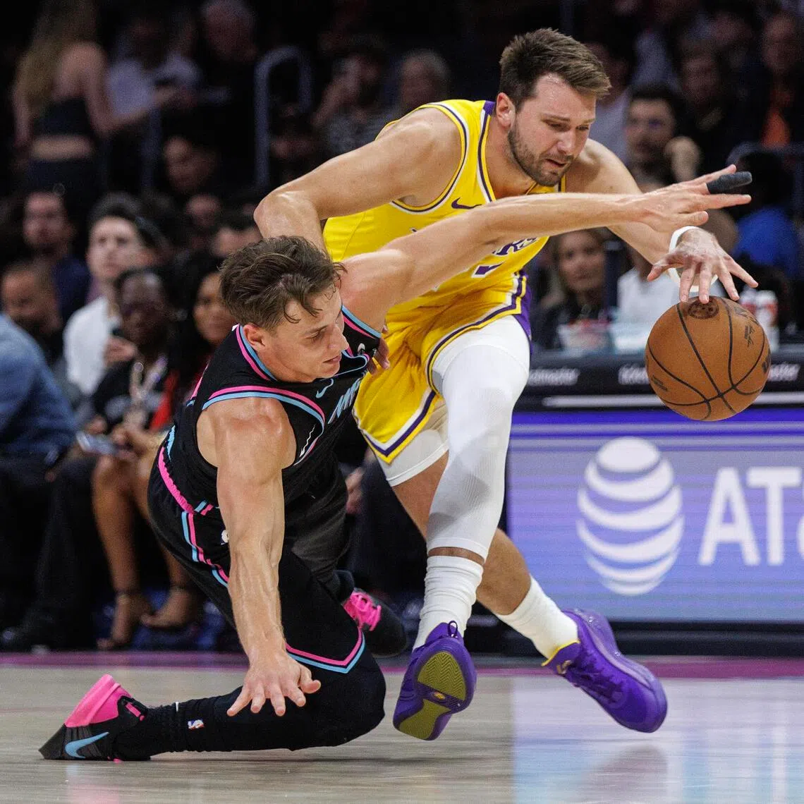 epa12835093 Miami Heat guard Pelle Larsson (L) in action against Los Angeles Lakers point guard Luka Doncic (R) during the NBA basketball game between the Miami Heat and the Los Angeles Lakers at the Kaseya Center in Miami, Florida, USA, 19 March 2026.  EPA/CRISTOBAL HERRERA-ULASHKEVICH  SHUTTERSTOCK OUT