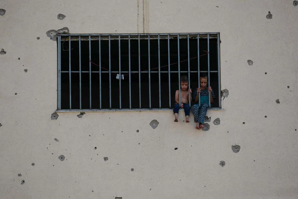 Palestinian children sitting on a window sill at the Asdaa central prison facility which has become a shelter for displaced people in Khan Yunis in the southern Gaza Strip on Aug 14, 2024, amid the ongoing conflict between Israel and the Hamas militant group.