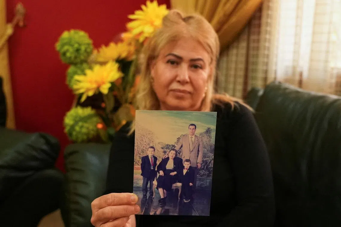 Sofia Ben Agla, wife of detained opposition leader Ghazi Chaouachi, poses for the camera while holding an old photo of herself, her husband, and their two sons inside her home in Tunis, Tunisia, on February 26, 2026. REUTERS/Stringer