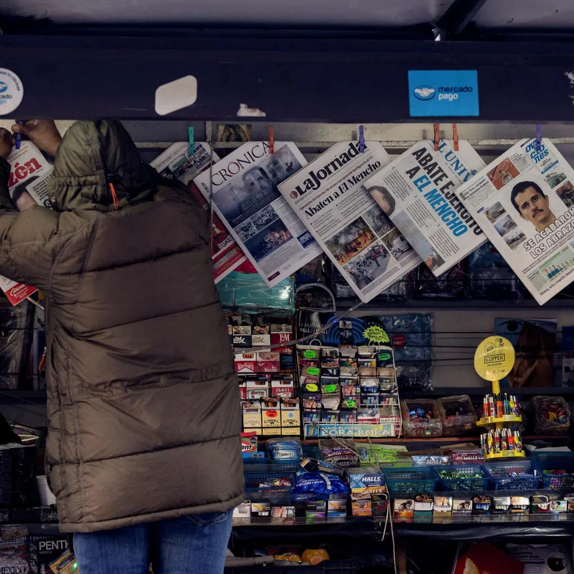 A newspaper seller arranges newspapers reporting the wave of violence in Mexico, following the killing of drug lord Nemesio Oseguera, known as 'El Mencho', in a military operation on Sunday, in Mexico City, Mexico, February 23, 2026. REUTERS/Quetzalli Nicte-Ha