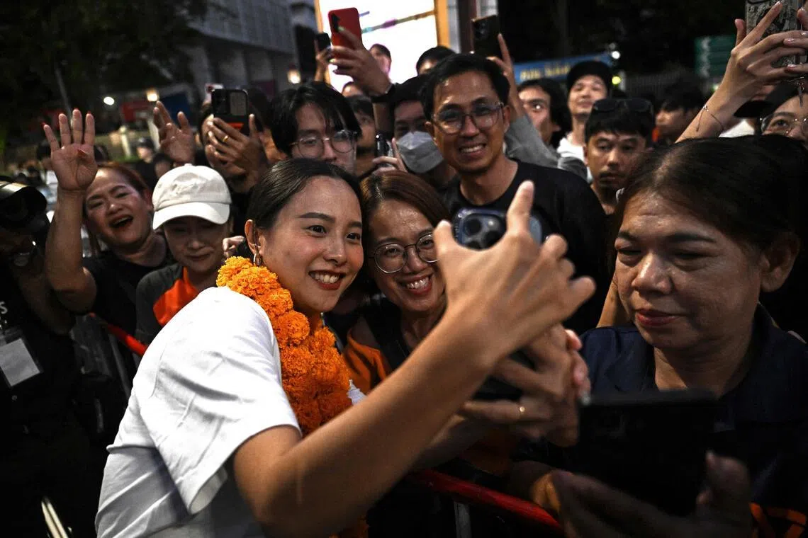 People’s Party MP Rukchanok Srinork takes photographs with supporters at a campaign rally in Bangkok.