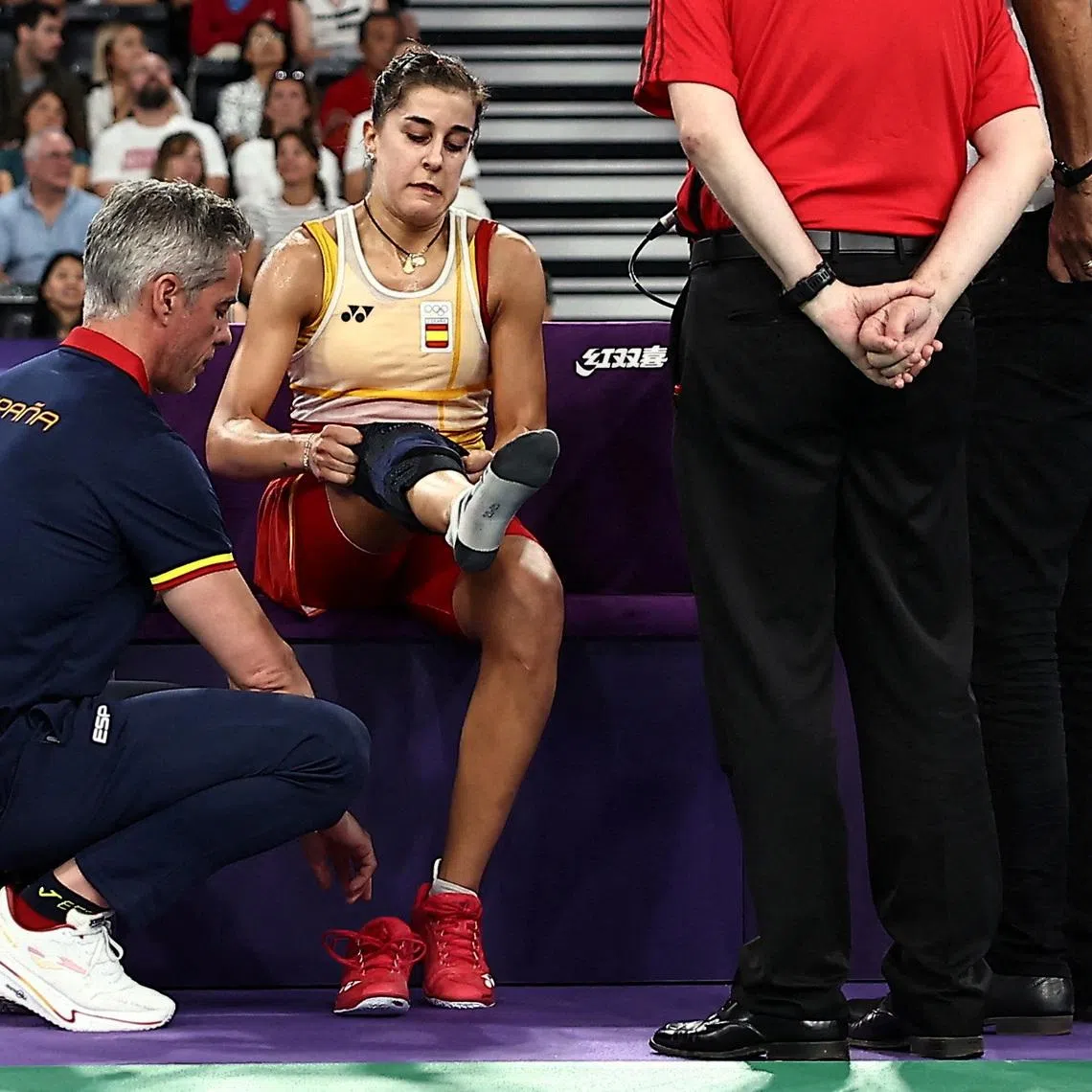FILE PHOTO: Paris 2024 Olympics - Badminton - Women's Singles Semifinals - Porte de La Chapelle Arena, Paris, France - August 04, 2024. Carolina Marin of Spain is attended to by coaching staff during the match against Bing Jiao He of China. REUTERS/Ann Wang/File Photo