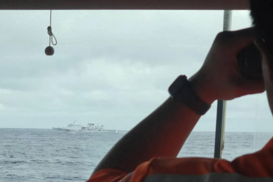 A crewmember on board a Taiwan Coast Guard ship monitors a Chinese coast guard vessel in waters east of Taiwan on Dec 7.