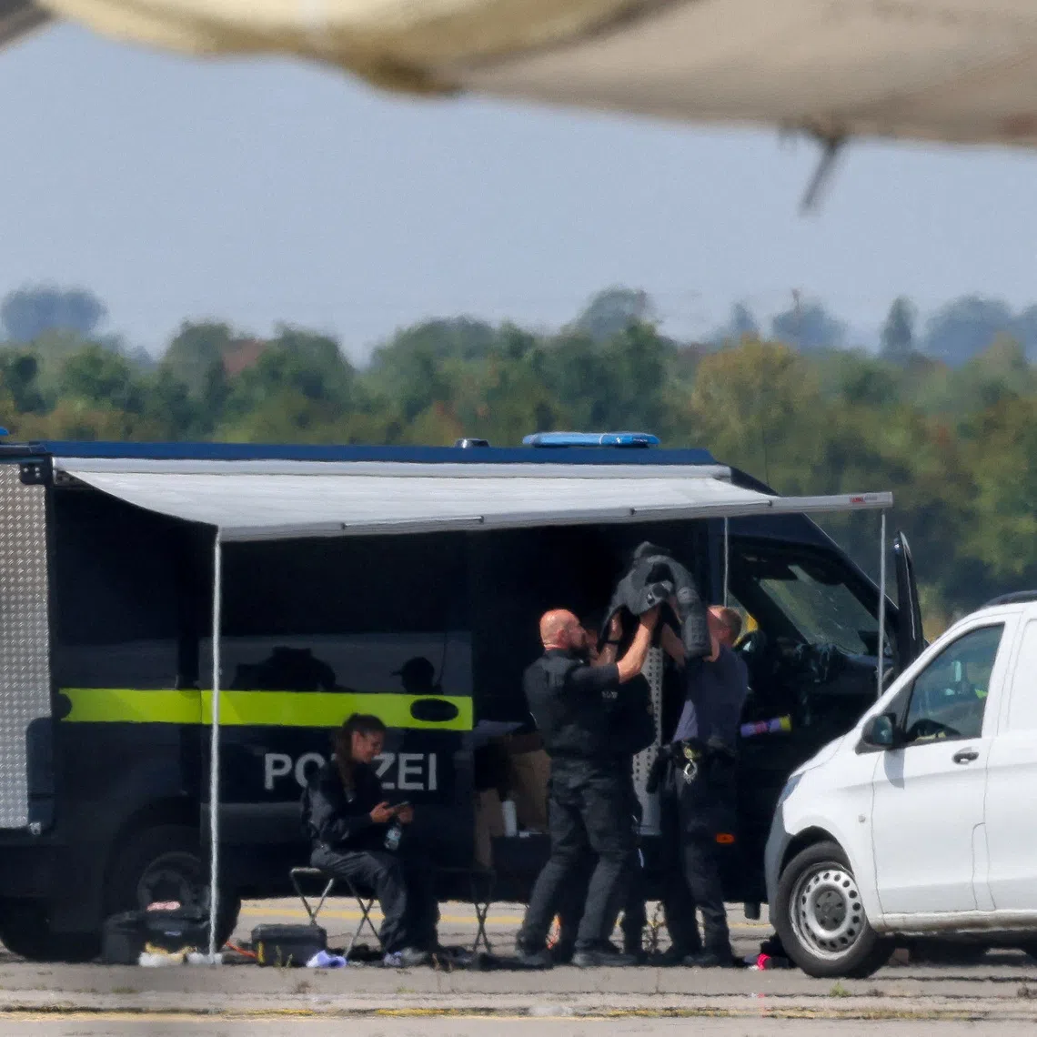 Police officers work in the vicinity of an Antonov cargo plane, near which a drone was found at Leipzig/Halle Airport in Schkeuditz, Germany, on Aug 5.