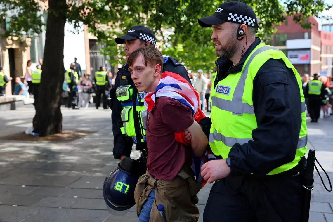 An anti-immigration protester is detained by police officers in the British city of Newcastle, on Aug 10.