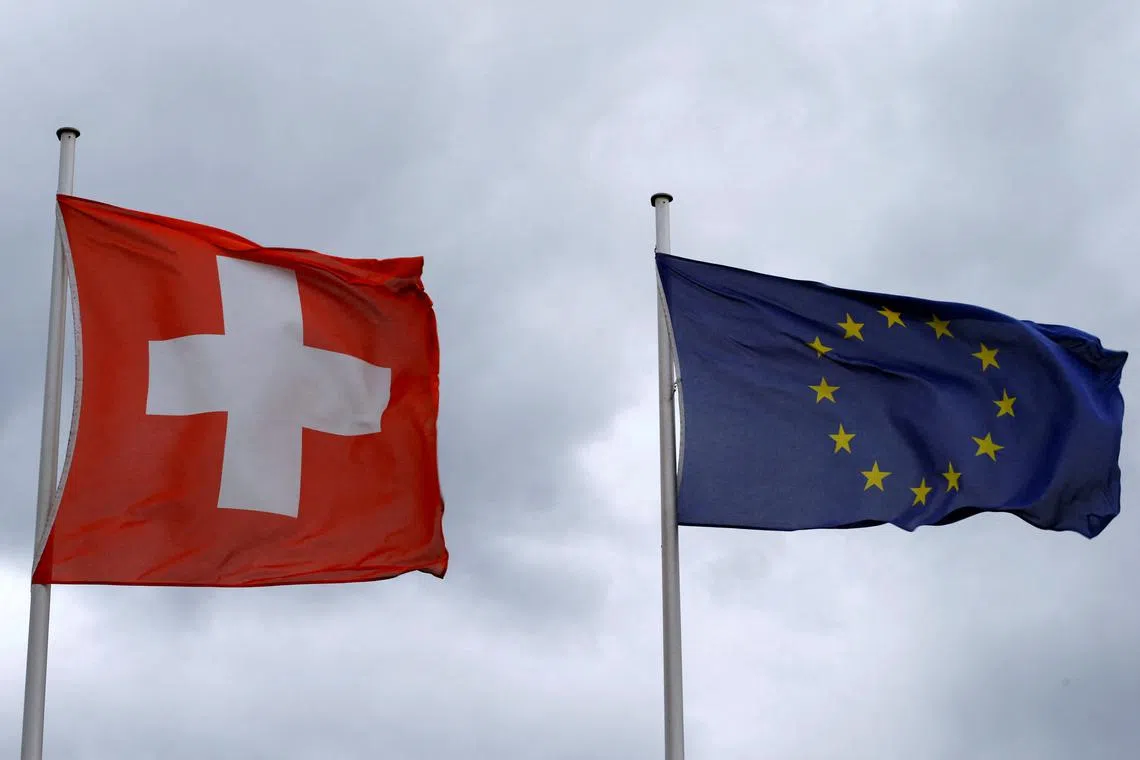 FILE PHOTO: An EU flag flies beside Switzerland's national flag near the German-Swiss border in Rheinfelden, Germany, March 11, 2019.   REUTERS/Arnd WIegmann/File Photo