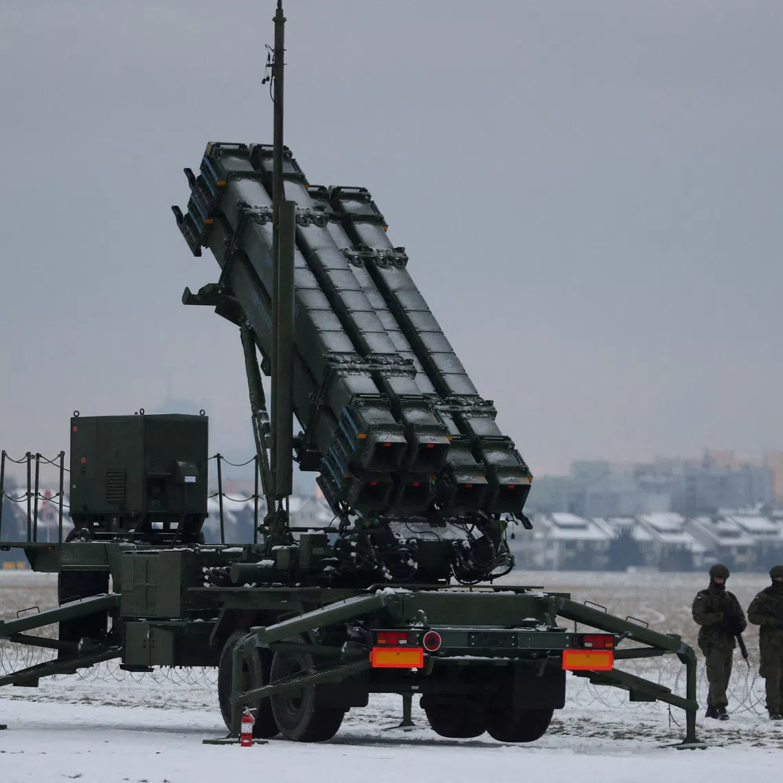 Servicemen patrol in front of the Patriot air defence system during Polish military training on the missile systems at the airport in Warsaw, Poland.