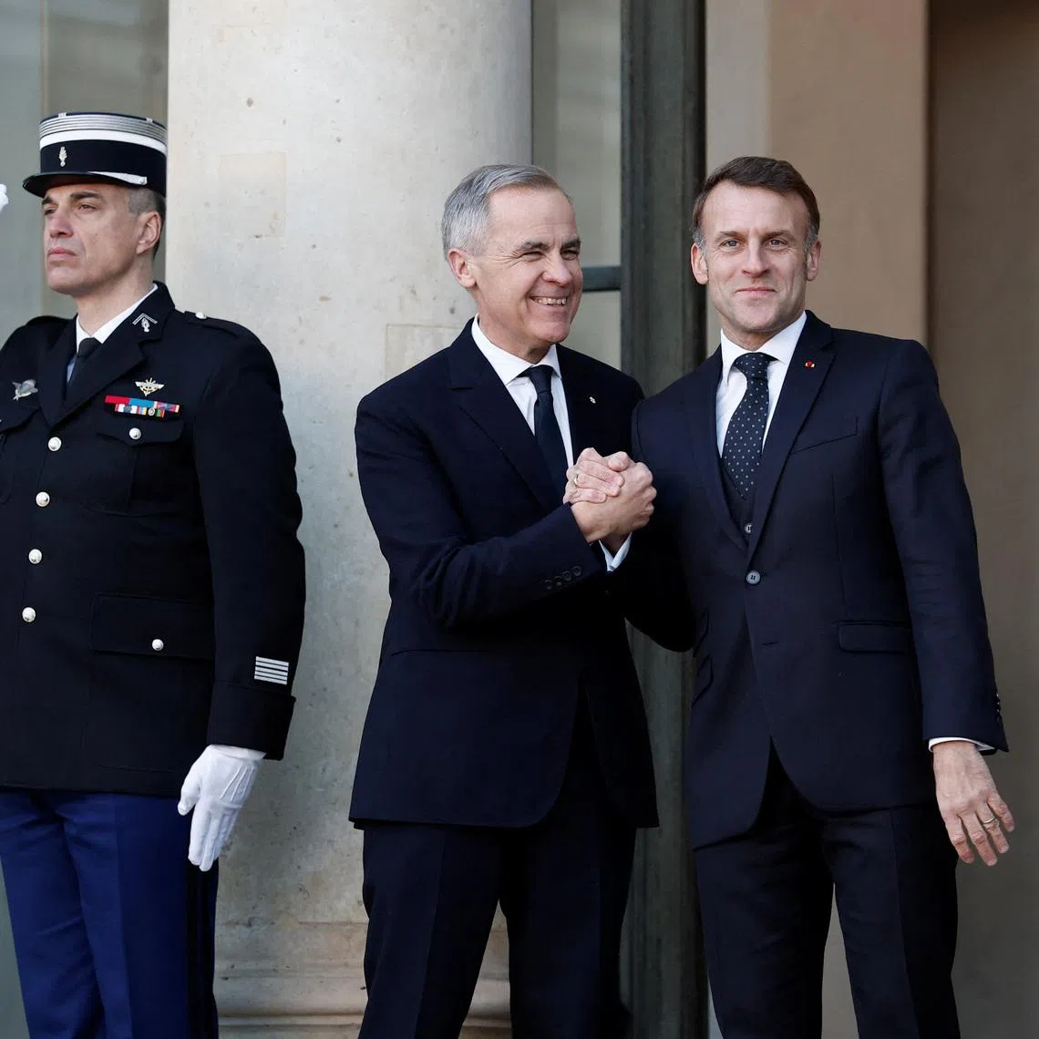 French President Emmanuel Macron (right) welcomes Canada's Prime Minister Mark Carney as he arrives for a summit at the Elysee Palace in Paris, France, on Jan 6.