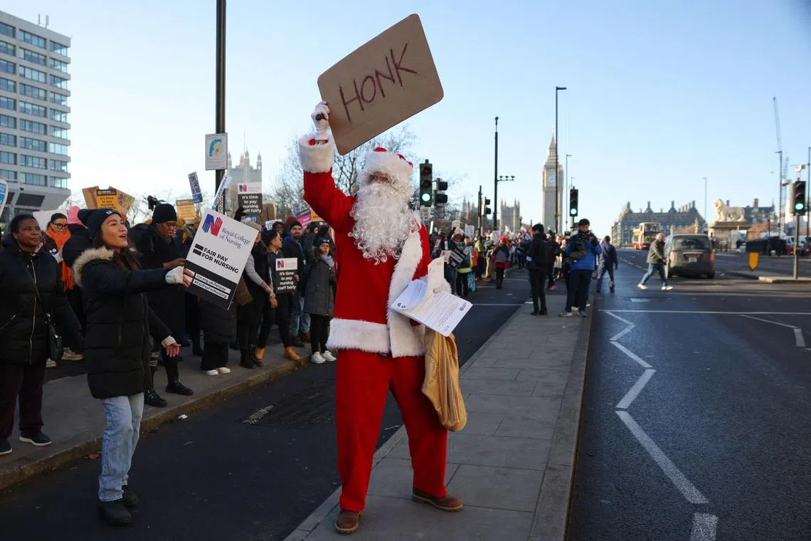 A demonstrator dressed as Father Christmas on a picket line during a strike by NHS nursing staff outside St. Thomas' Hospital in London, UK, on Thursday, Dec. 15, 2022. Unprecedented walkouts by as many as 100,000 nursing staff on Dec. 15 and Dec. 20 will go ahead after ministers on Sunday rejected a union offer to suspend industrial action in return for talks over pay. Photographer: Hollie Adams/Bloomberg