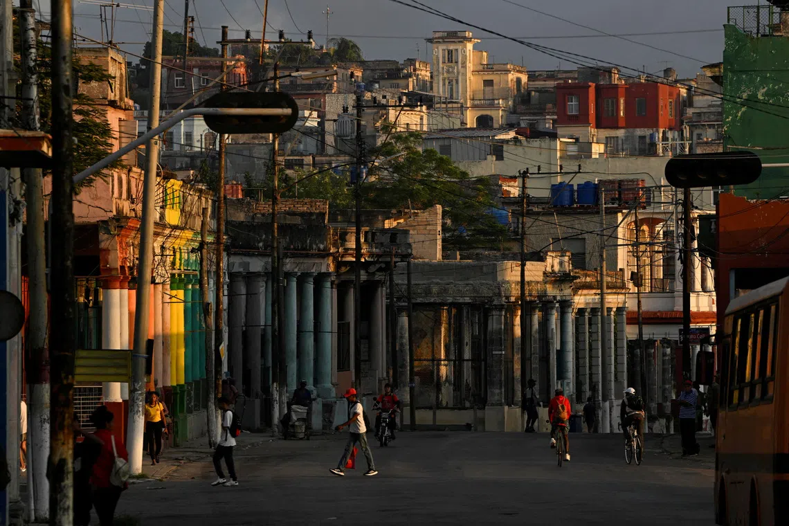 People walking along a street amid a partial collapse of the electrical grid, in Havana, Cuba, on Dec 3, 2025. 