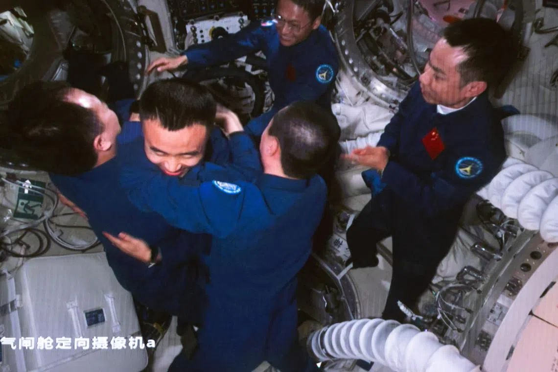 Astronauts of the Shenzhou-16 mission greeting the Shenzhou-17 crew at China's space station.