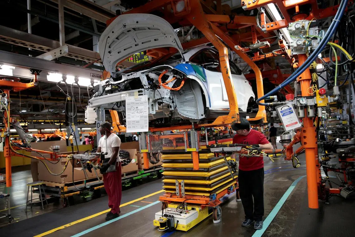FILE PHOTO: General Motors assembly workers connect a battery pack underneath a partially assembled 2018 Chevrolet Bolt EV vehicle on the assembly line at  Orion Assembly in Lake Orion, Michigan, U.S., March 19, 2018.  Photo taken March 19, 2018.   REUTERS/Rebecca Cook/File Photo