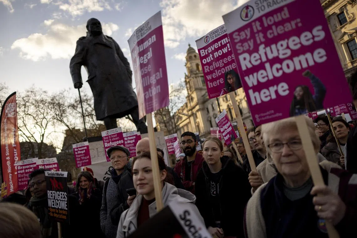 Pro-immigration campaigners protest outside the Houses of Parliaments in London.