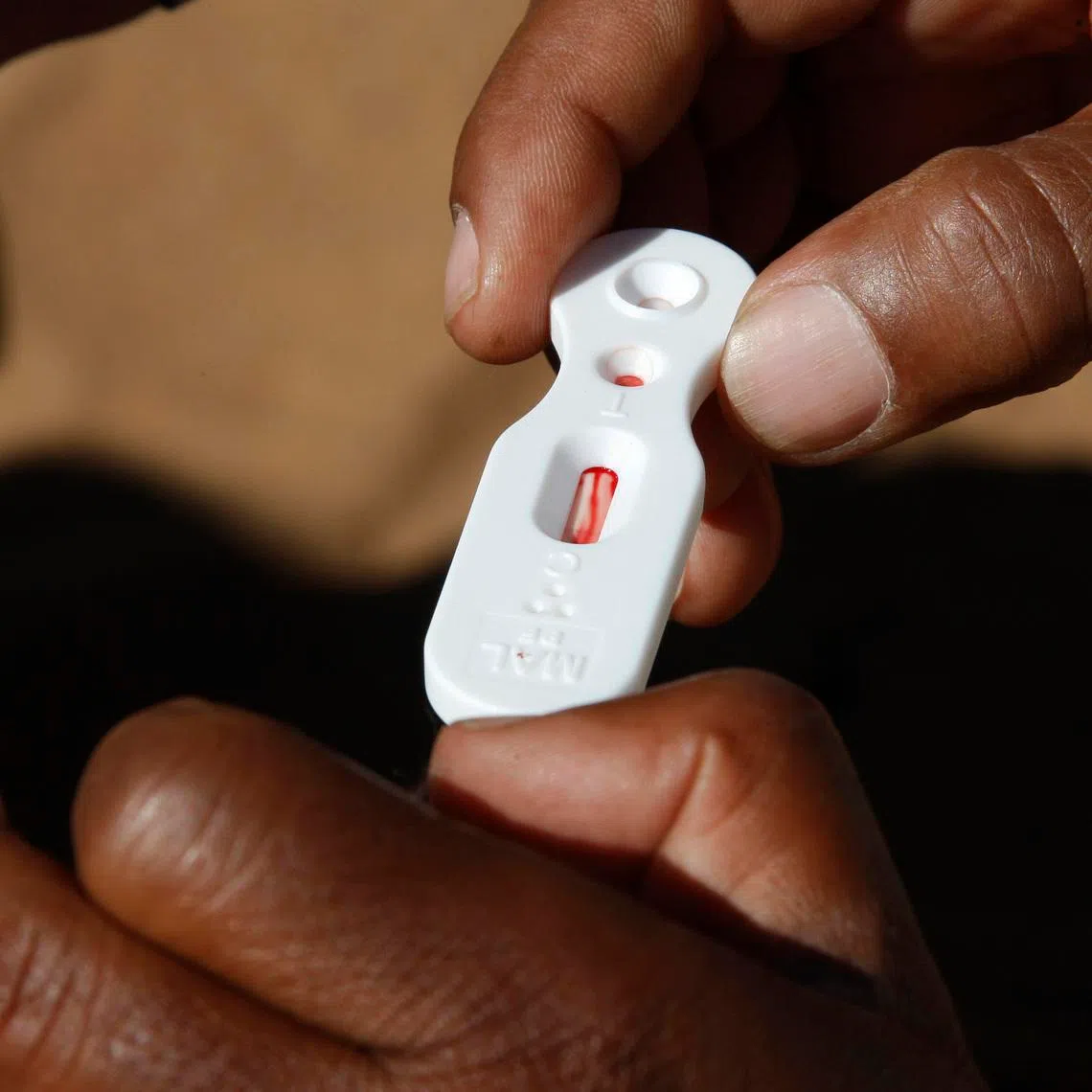 FILE PHOTO: A Zambian healthcare worker checks a malaria test in this file photo in Matongo village, April 23, 2008. REUTERS/Thierry Roge (ZAMBIA)/File Photo