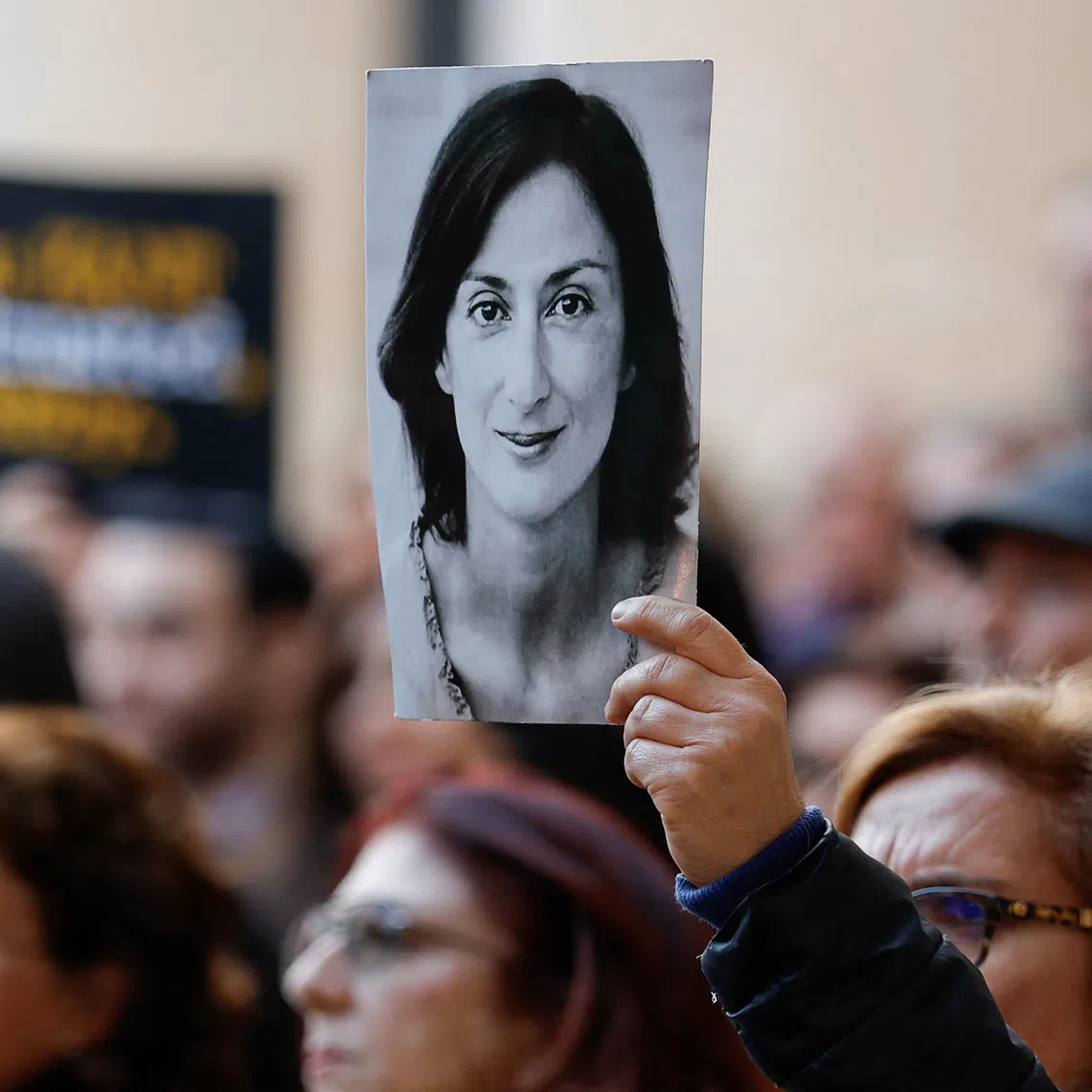 FILE PHOTO: A demonstrator holds up an image of assassinated journalist Daphne Caruana Galizia, during a protest in Valletta, Malta, February 16, 2025.  REUTERS/Darrin Zammit Lupi/File photo
