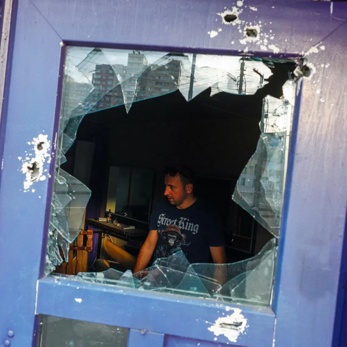 A resident removing debris at his barbershop in Kyiv on July 11, after Russia launched missiles and drones at Ukraine.