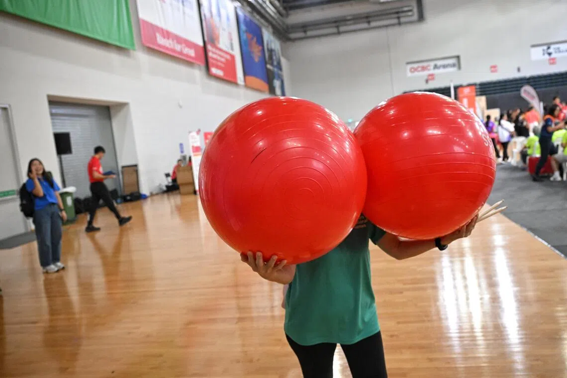 A senior caries exercise balls before a performance during the Seniors National Games Finals held at the OCBC Arena on August 4, 2026.