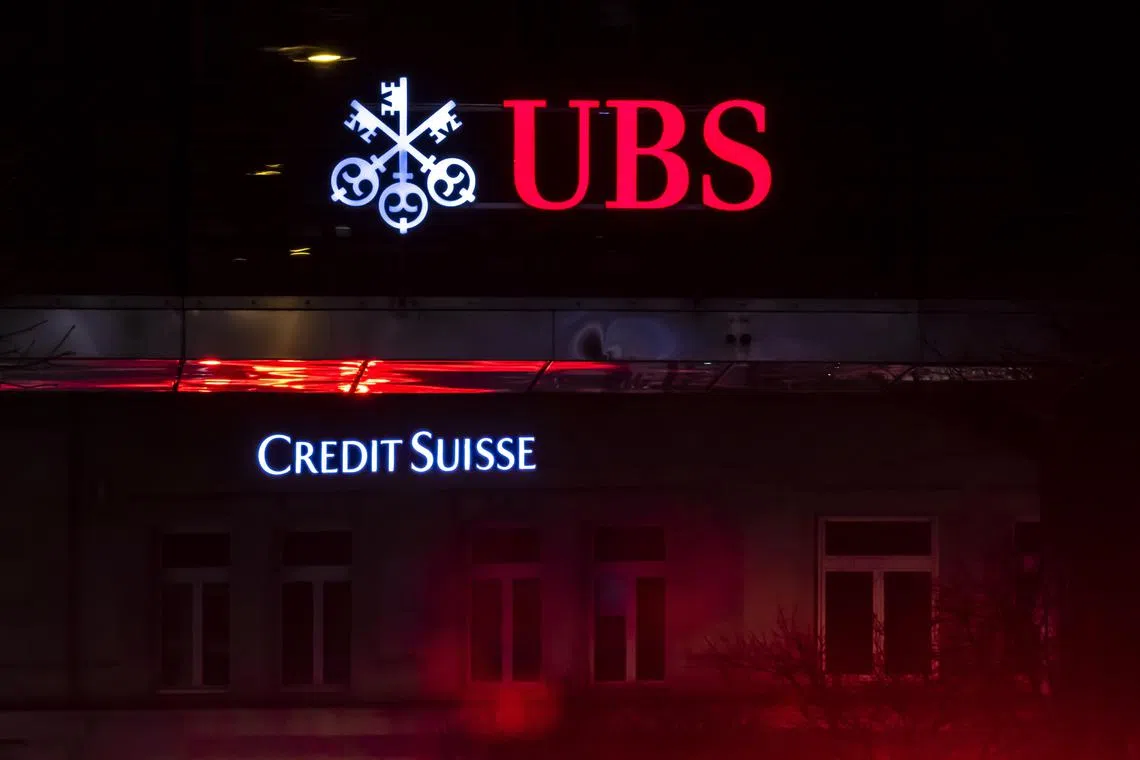 The illuminated logos of the Swiss banks Credit Suisse and UBS are displayed on buildings in Zurich, on March 18.  