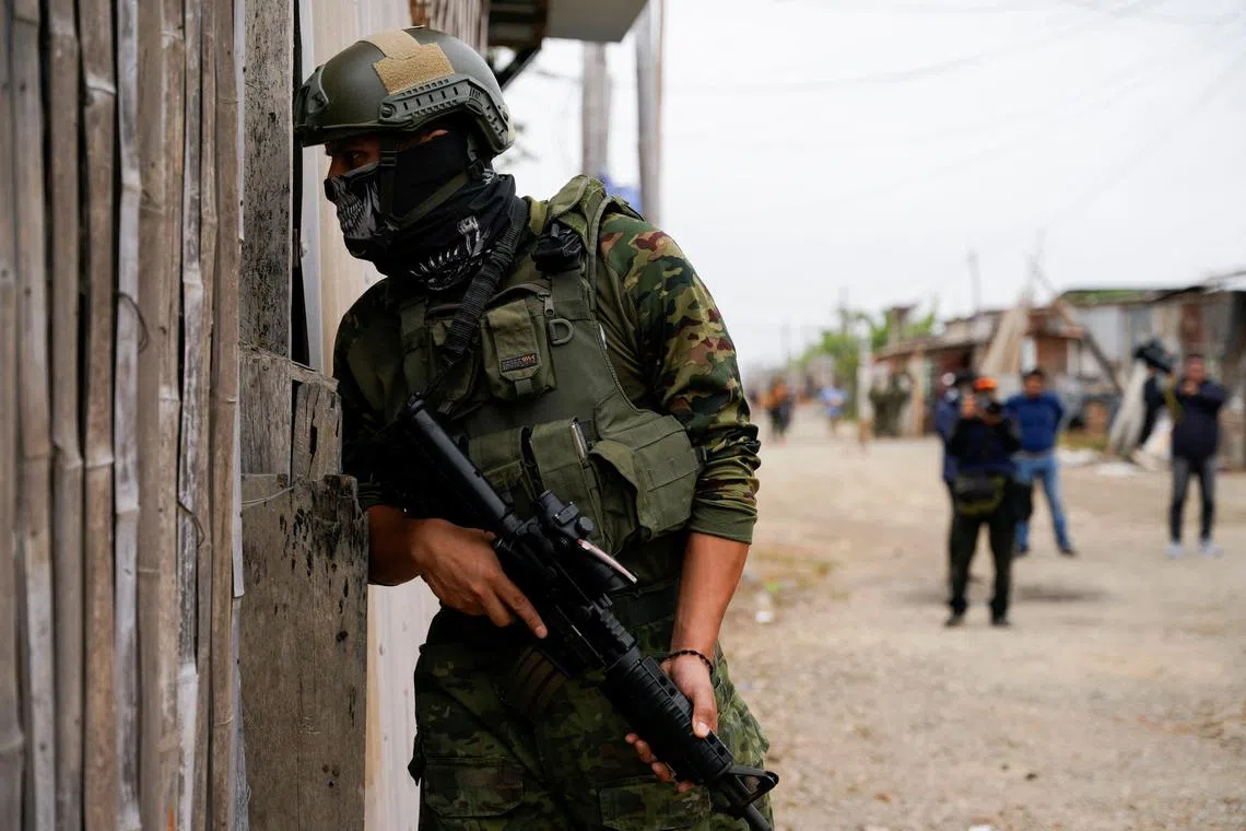 A soldier searches for members of drug gangs, hidden weapons or drugs during a government operation to return homes, allegedly stolen by drug gangs, to their rightful owners, in Duran, Ecuador July 19, 2024. REUTERS/Santiago Arcos/File Photo