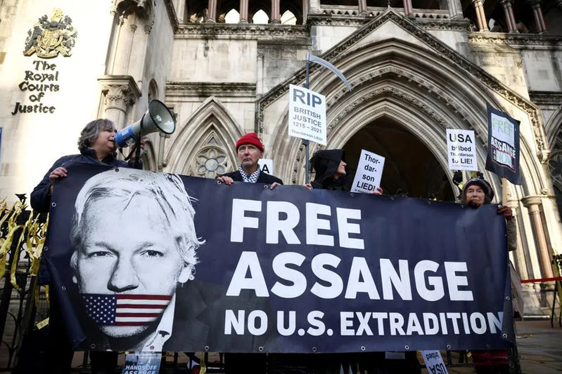 Supporters of Julian Assange display signs and a banner, outside the Royal Courts of Justice in London, Britain December 10, 2021. REUTERS/Henry Nicholls/File Photo